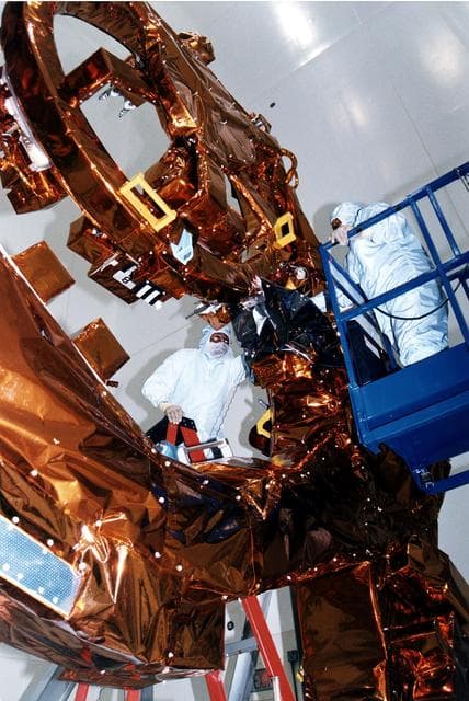 NASA image: KENNEDY SPACE CENTER, FLA. -  Workers in KSC's Vertical Processing Facility make final adjustments to the Flight Support System (FSS) for STS-82, the second Hubble Space Telescope servicing mission.  The FSS is reusable flight hardware that provides the mechanical, structural and electrical interfaces between HST, the space support equipment and the orbiter for payload retrieval and on-orbit servicing.  Liftoff aboard Discovery is targeted Feb. 11 with a crew of seven.