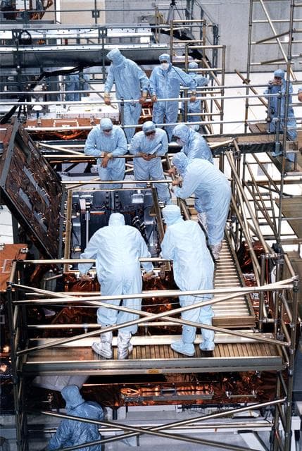 NASA image: KENNEDY SPACE CENTER, FLA. -  STS-82 crew members and workers at KSC's Vertical Processing Facility get a final look at the Near Infrared Camera and Multi-Object Spectrometer (NICMOS) in its flight configuration for the STS-82 mission.  The crew is participating in the Crew Equipment Integration Test (CEIT).  NICMOS is one of two new scientific instruments that will replace two outdated instruments on the Hubble Space Telescope (HST).  NICMOS will provide HST with the capability for infrared imaging and spectroscopic observations of astronomical targets.  The refrigerator-sized NICMOS also is HST's first cryogenic instrument - its sensitive infrared detectors must operate at very cold temperatures of minus 355 degrees Fahrenheit or 58 degrees Kelvin.  NICMOS will be installed in Hubble during STS-82, the second Hubble Space Telescope servicing mission.  Liftoff is scheduled Feb. 11 aboard Discovery with a crew of seven.