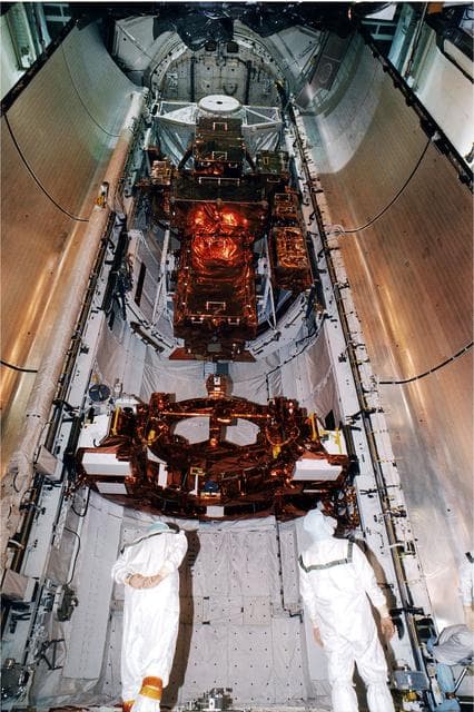 NASA image: KENNEDY SPACE CENTER, FLA. -   At the KSC Launch Pad 39A, two members of the payload closeout crew check equipment as the doors are just about ready to be closed.  The Payload inside the bay of Discovery, the orbiter for the STS-82 mission, is ready for the launch of the second Hubble Space Telescope service mission.  The payload consists of the Near Infrared Camera and Multi-Object Spectrometer (NICMOS) that will be installed, Fine Guidance Sensor #1 (FGS-1), and the Space Telescope Imaging Spectrograph (STIS) to be installed. The STS-82 will launch with a crew of seven at 3:54 a.m. EST, Feb. 11, 1997. The launch window is 65 minutes in duration. The Mission Commander for STS-82 is Ken Bowersox. The purpose of the mission is to upgrade the scientific capabilities, service or replace aging components on the Telescope and provide a reboost to the optimum altitude.