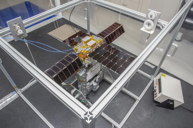 NASA image: Spacecraft in Gravity Off-load Fixture (GOLF), System Test configuration - Arisa Waddle – Test Engineer,  Rick Wilson – Lead Test Engineer