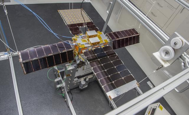 NASA image: Spacecraft in Gravity Off-load Fixture (GOLF), System Test configuration - Arisa Waddle – Test Engineer,  Rick Wilson – Lead Test Engineer