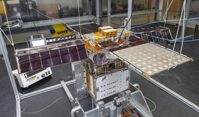 NASA image: Spacecraft in Gravity Off-load Fixture (GOLF), System Test configuration - Arisa Waddle – Test Engineer,  Rick Wilson – Lead Test Engineer