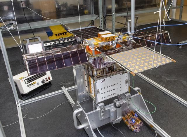 NASA image: Spacecraft in Gravity Off-load Fixture (GOLF), System Test configuration - Arisa Waddle – Test Engineer,  Rick Wilson – Lead Test Engineer