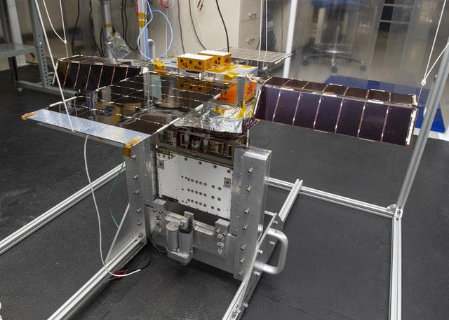 NASA image: Spacecraft in Gravity Off-load Fixture (GOLF), System Test configuration - Arisa Waddle – Test Engineer,  Rick Wilson – Lead Test Engineer