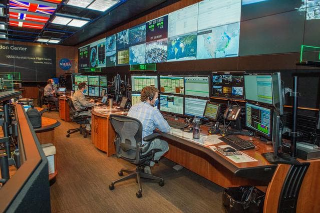 NASA image: A look inside the International Space Station Payload Operations Integration Center at NASA’s Marshall Space Flight Center in Huntsville, AL.  The POIC team supports science operations on the International Space Station 24 hours a day, 7 days a week. For more than 20 years the POIC team has worked with scientists from around the world to enable the space station crew to conduct experiments that improve life on Earth and enable future exploration.