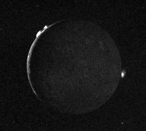 NASA image: Io - Crescent with Plumes