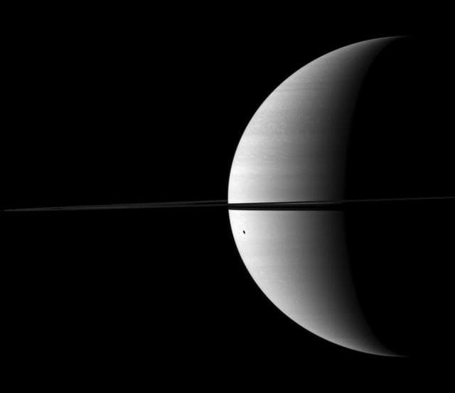 NASA image: Dione Distorted Shadow