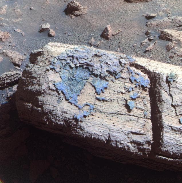 NASA image: Rock with Odd Coating Beside a Young Martian Crater, False Color