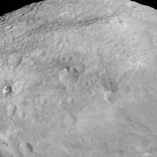 NASA image: Dark Patches and Stripes on Crater Walls