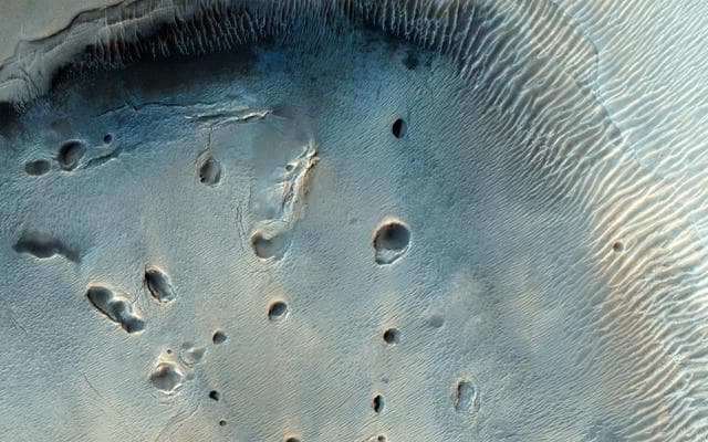 NASA image: A Dark-Toned, Pitted Mound in a Crater in Northeast Arabia Terra