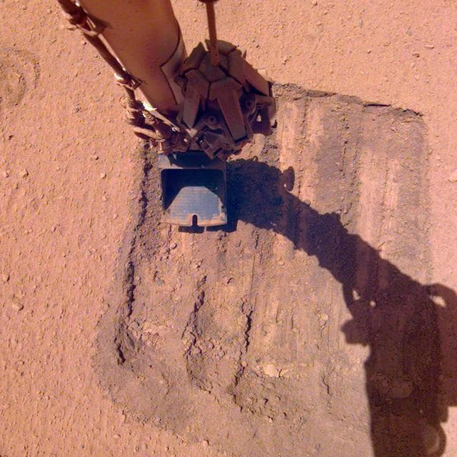 NASA image: InSight's Robotic Arm Helps Remove Solar Panel Dust Trickles Sand in the Wind