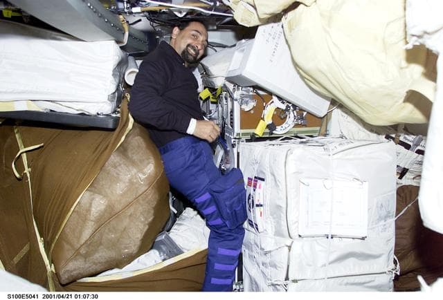 NASA image: MS Guidoni works among stowage bags on the middeck of Endeavour