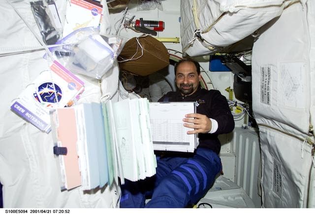 NASA image: MS Guidoni looks over a checklist on the middeck of Endeavour