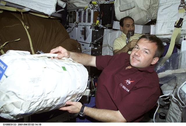 NASA image: MS Guidoni and MS Lonchakov work with stowage bags on the middeck of Endeavour