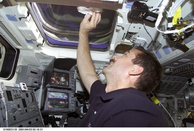 NASA image: MS Hadfield cleans an overhead window on the aft flight deck of Endeavour