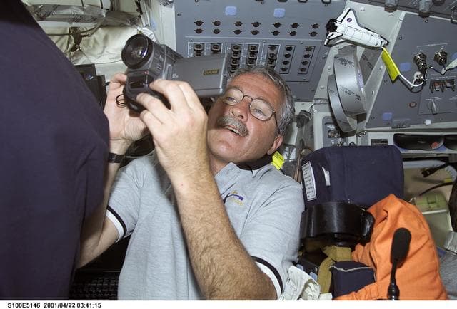 NASA image: MS Phillips uses a video camera on the flight deck of Endeavour during STS-100