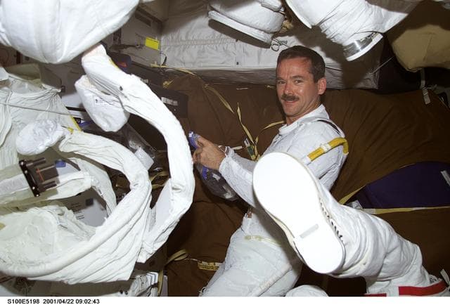 NASA image: MS Hadfield prepares to don his EMU on the middeck of Endeavour