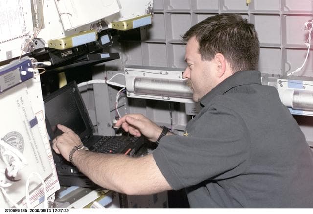 NASA image: Pilot Altman works with the SOAR laptop computer in SpaceHab during STS-106
