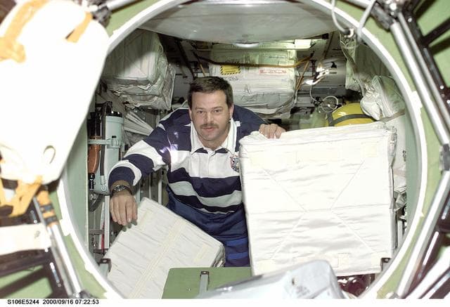 NASA image: Pilot Altman transfers stowage equipment into the ISS during STS-106