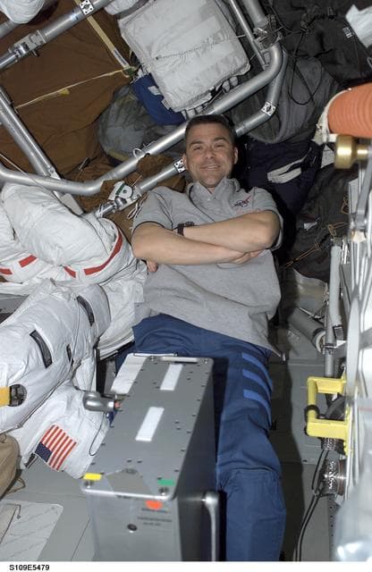 NASA image: STS-109 PLT Carey on middeck with ergometer