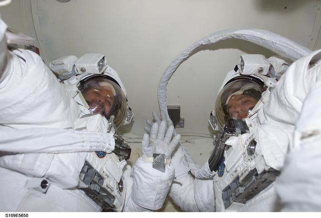 NASA image: MS Grunsfeld and Linnehan wearing EMU in airlock prepares for EVA 3