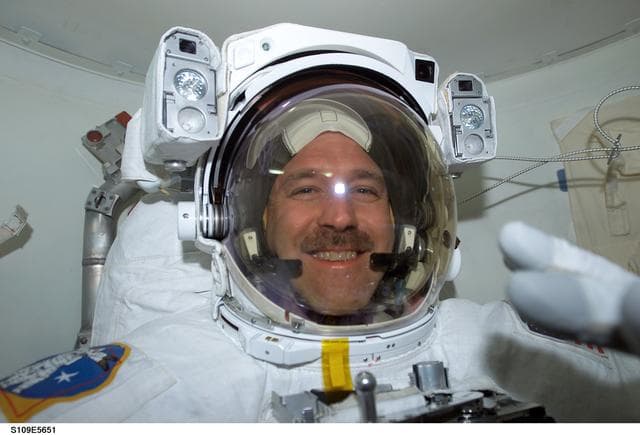 NASA image: MS Grunsfeld  wearing EMU in airlock prepares for EVA 3
