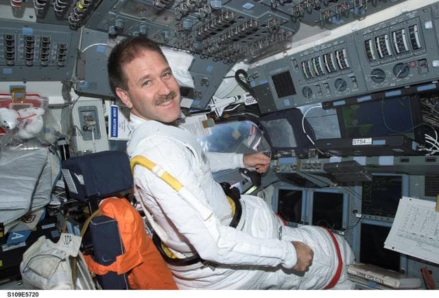 NASA image: MS Grunsfeld at commander's station on forward flight deck