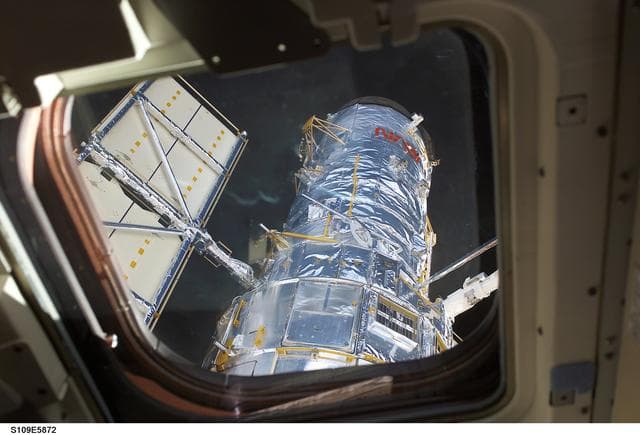 NASA image: HST removed from payload bay by RMS arm