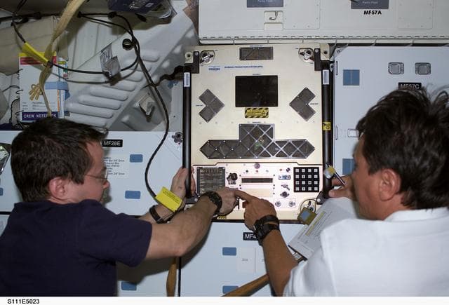 NASA image: Bursch and Chang-Diaz install the BPS in a slot on Endeavour's middeck for return on STS-111 UF-2