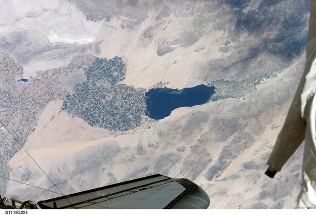 NASA image: Chang-Diaz's EMU lower torso (legs) suspended against an Earth view during STS-111 UF-2 EVA 2