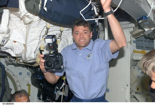 NASA image: STS-112 CDR Ashby on middeck with camera