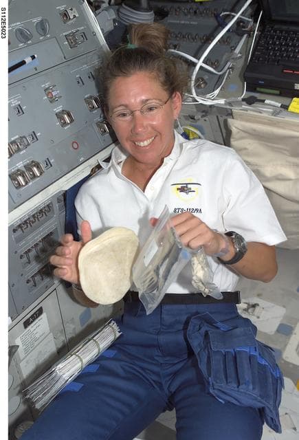 NASA image: MS Magnus with foot and utensils on flight deck