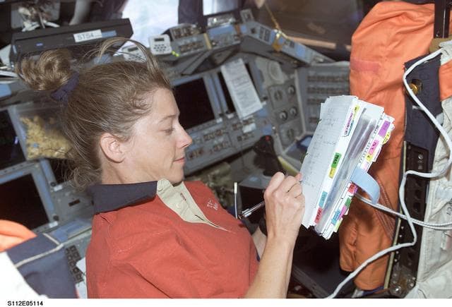 NASA image: STS-112 PLT Melroy with checklist on flight deck