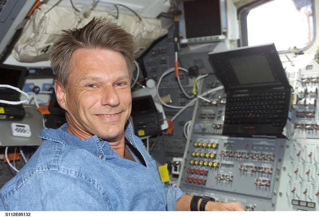 NASA image: MS Sellers on orbiter Atlantis flight deck with laptop