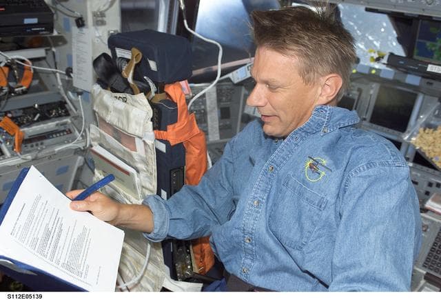 NASA image: MS Sellers on flight deck with checklist