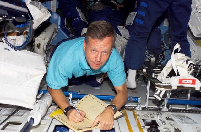 NASA image: Lindsey writes in the ISS Ships Log during  STS-121 / Expedition 13 joint operations