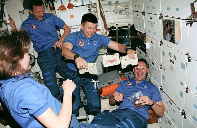 NASA image: STS-37 crewmembers watch Pilot Cameron juggle cassettes on OV-104's middeck