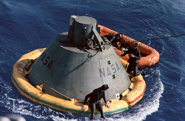 NASA image: Frogmen on Apollo command module boilerplate flotation collar during recovery