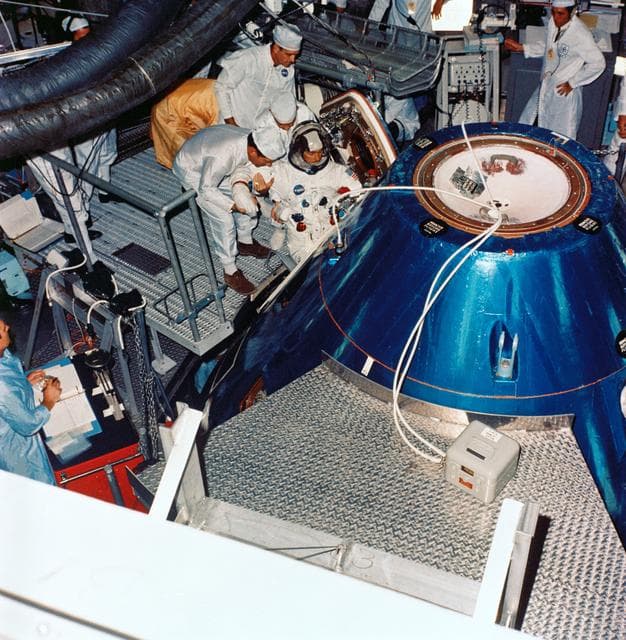 Astronaut John Young ingresses Apollo spacecraft command module in training