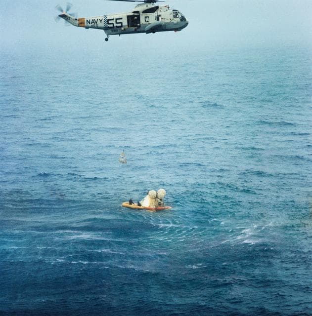 NASA image: Member of Apollo 7 crew hoisted to helicopter during recovery operations