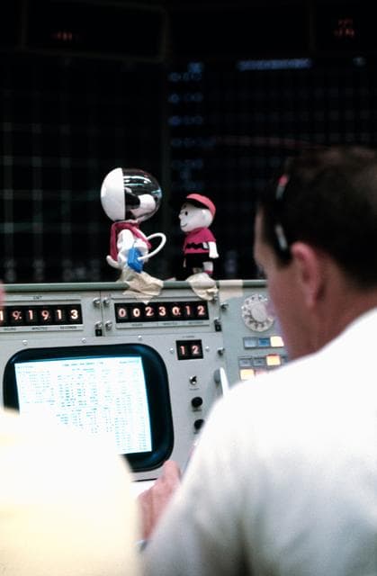 Replicas of Snoopy and Charlie Brown decorate top of console in MCC