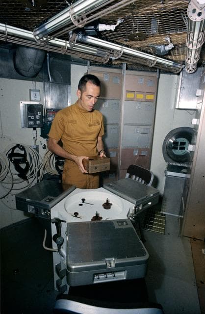 NASA image: Astronaut Robert Crippen holds training model of Skylab experiment