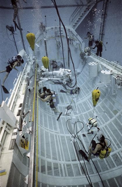 NASA image: STS-37 crewmembers move CETA electrical cart along rail in JSC's WETF pool