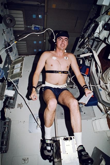 NASA image: STS-46 Pilot Allen uses cycle ergometer on OV-104's middeck