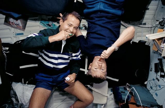 NASA image: Astronauts Culbertson and Bursch brush their teeth on Discovery's middeck