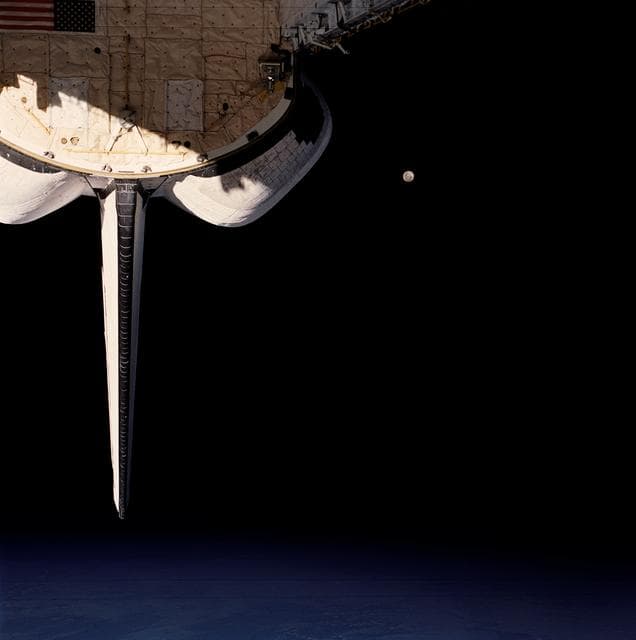 NASA image: STS-53 view of OV-103's payload bay (PLB), the Moon, and Earth's surface