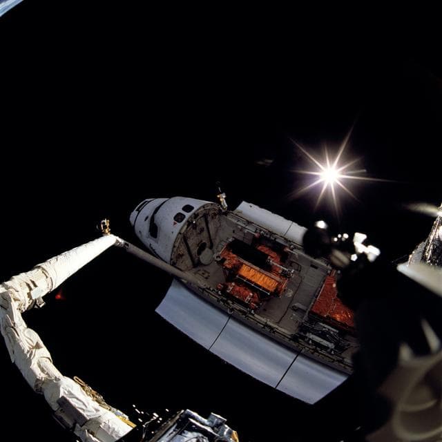 NASA image: Endeavour backdropped against space with Sun displaying rayed effect