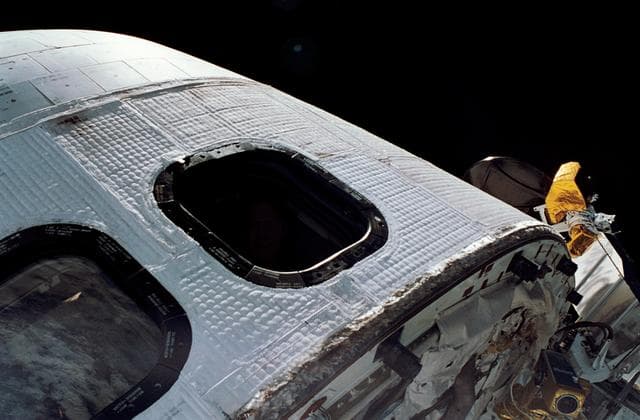 Astronaut Richard Richards looks out of Discovery's flight deck window