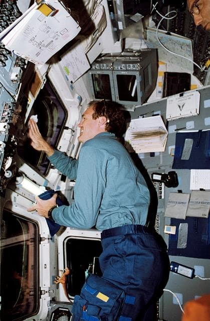 NASA image: STS-65 Pilot Halsell cleans window on the aft flight deck of Columbia, OV-102