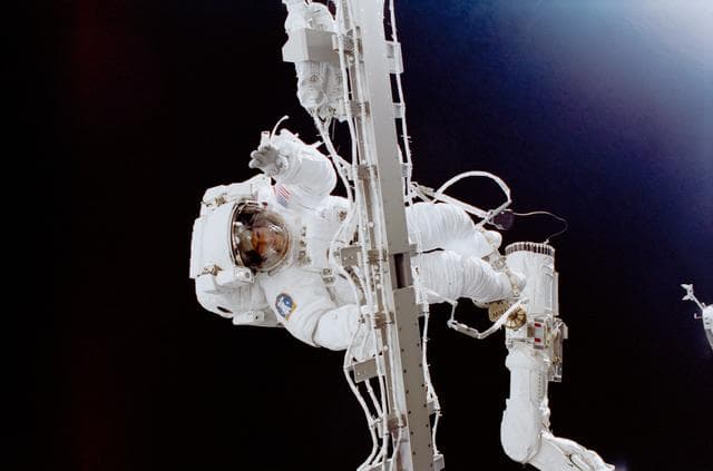NASA image: Helms holds onto the Rigid Umbilical during EVA